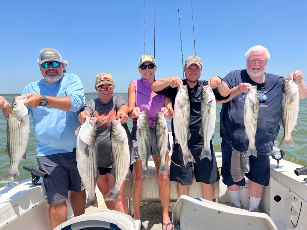 Fishing group holding their catch aboard a Lake Texoma guide boat